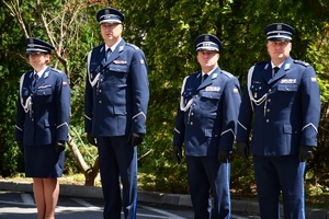 Policjanci podczas uroczystości złożenia kwiatów i zapalenia zniczy przed tablicami pamiątkowymi na frontonie Komendy Wojewódzkiej Policji w Rzeszowie