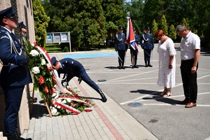 Policjanci podczas uroczystości złożenia kwiatów i zapalenia zniczy przed tablicami pamiątkowymi na frontonie Komendy Wojewódzkiej Policji w Rzeszowie