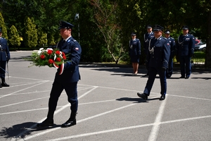 Policjanci podczas uroczystości złożenia kwiatów i zapalenia zniczy przed tablicami pamiątkowymi na frontonie Komendy Wojewódzkiej Policji w Rzeszowie