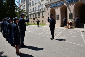 Policjanci podczas uroczystości złożenia kwiatów i zapalenia zniczy przed tablicami pamiątkowymi na frontonie Komendy Wojewódzkiej Policji w Rzeszowie