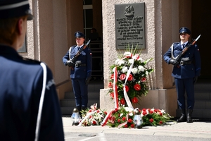 Policjanci podczas uroczystości złożenia kwiatów i zapalenia zniczy przed tablicami pamiątkowymi na frontonie Komendy Wojewódzkiej Policji w Rzeszowie