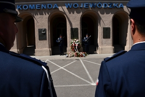 Policjanci podczas uroczystości złożenia kwiatów i zapalenia zniczy przed tablicami pamiątkowymi na frontonie Komendy Wojewódzkiej Policji w Rzeszowie