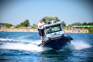 Policjanci podaczas pracy na drodze, radiowóz oraz policjanci na łodzi.