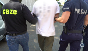 Policjanci prowadzą zatrzymanego