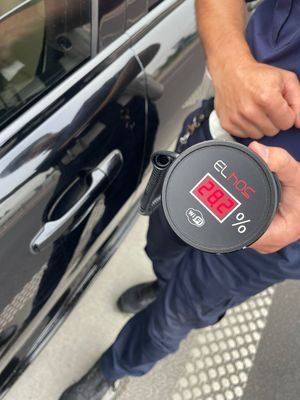 Urządzenie do pomiaru przejrzystości szyb trzymane w ręku policjanta