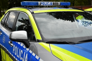 Policjanci i nowe radiowozy na placu.