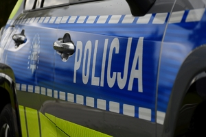 Policjanci i nowe radiowozy na placu.