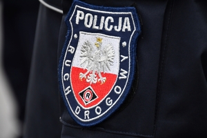 Policjanci i nowe radiowozy na placu.