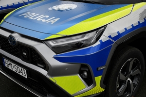 Policjanci i nowe radiowozy na placu.