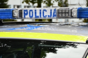 Policjanci i nowe radiowozy na placu.