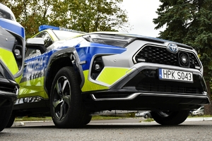 Policjanci i nowe radiowozy na placu.