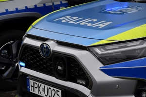 Policjanci i nowe radiowozy na placu.