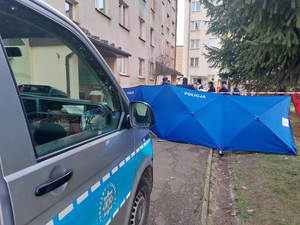 Zdjęcie z miejsca zdarzenia na którym widoczny jest częściowo radiowóz oraz parawan.
