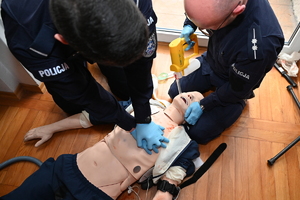 Policjanci podczas recertyfikacji. Dwaj policjanci prowadzą akcję ratunkową z manekinem.