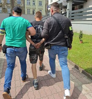 nieumundurowani policjanci doprowadzają zatrzymanych do jednostek policji