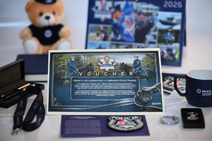 Policyjne gadżety przekazane na licytację. Voucher, policyjna maskotka, kalendarz, notatnik, proporczyk, kubek, smycz.