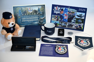 Policyjne gadżety przekazane na licytację. Voucher, policyjna maskotka, kalendarz, notatnik, proporczyk, kubek, smycz.