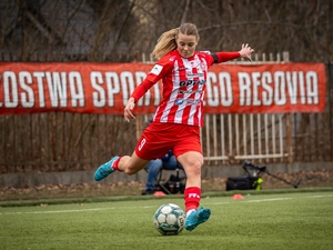 Policjantka - piłkarka, w stroju piłkarskim na boisku