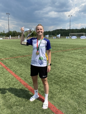 Policjantka - piłkarka, w stroju piłkarskim na boisku