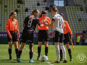 Policjantka - piłkarka, w stroju piłkarskim na boisku