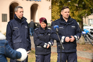 Dwaj policjanci i policjantka podczas udzielania wywiadów w trakcie briefingu przed budynkiem Komendy Wojewódzkiej Policji w Rzeszowie