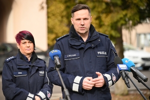 Dwaj policjanci i policjantka podczas udzielania wywiadów w trakcie briefingu przed budynkiem Komendy Wojewódzkiej Policji w Rzeszowie