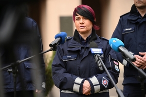 Dwaj policjanci i policjantka podczas udzielania wywiadów w trakcie briefingu przed budynkiem Komendy Wojewódzkiej Policji w Rzeszowie