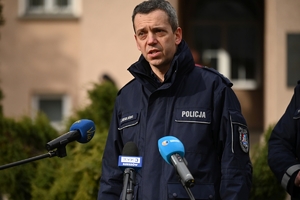 Dwaj policjanci i policjantka podczas udzielania wywiadów w trakcie briefingu przed budynkiem Komendy Wojewódzkiej Policji w Rzeszowie