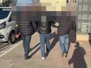 Policjanci prowadzą zatrzymanego