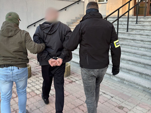 Policjanci prowadzą zatrzymanego