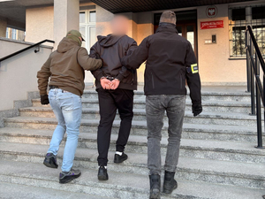 Policjanci prowadzą zatrzymanego