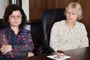 Uczestnicy spotkania w sali sztabowej Komendy Wojewódzkiej Policji w Rzeszowie. Uczestnicy siedzą przy stole, w tle na ścianie logo Komendy Wojewódzkiej Policji w Rzeszowie i napis  Komenda Wojewódzka Policji w Rzeszowie.