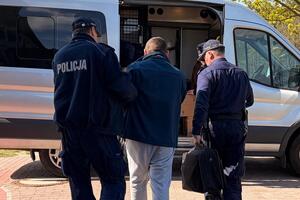 Policjanci prowadzą zatrzymanego mężczynę