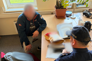 Policjanci prowadzą zatrzymanego mężczynę