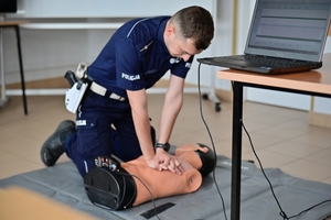 Policjanci podczas konkurencji udzielania pierwszej pomocy - z fantomem do ćwiczeń.