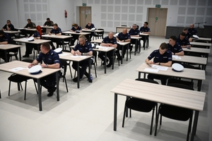 Policjanci podczas pisania testu na auli Oddziału Prewencji Policji w Rzeszowie.