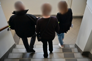 Funkcjonariusze prowadzący kobietę podejrzaną o korupcję menadżerską
