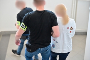 Funkcjonariusze prowadzący kobietę podejrzaną o korupcję menadżerską