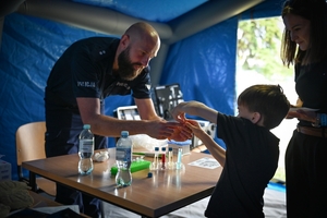 Uczestnicy pikniku policyjnego oglądający stoiska podczas imprezy na obiektach Oddziału Prewencji Policji w Rzeszowie.