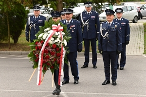 Policjanci podczas uroczystości pod tablicami poświęconymi pamięci poległych policjantów