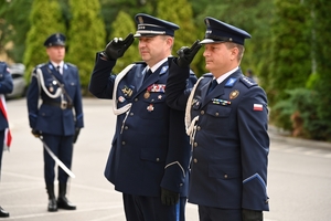 Policjanci podczas uroczystości pod tablicami poświęconymi pamięci poległych policjantów