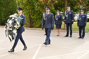 Policjanci podczas uroczystości pod tablicami poświęconymi pamięci poległych policjantów