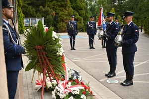 Policjanci podczas uroczystości pod tablicami poświęconymi pamięci poległych policjantów