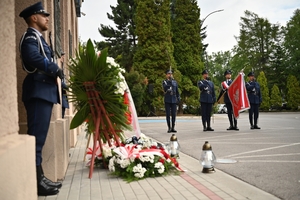 Policjanci podczas uroczystości pod tablicami poświęconymi pamięci poległych policjantów
