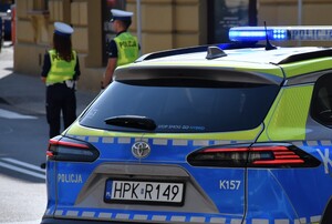 Policjanci oraz radiowóz na drodze