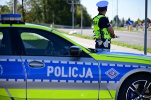 Policjant ruchu drogowego oraz radiowóz policyjny