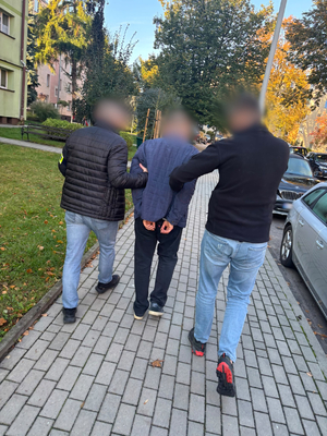 Policjanci prowadzą zatrzymanego