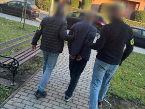 Policjanci prowadzą zatrzymanego