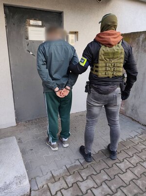 Policjanci prowadzą zatrzymanego