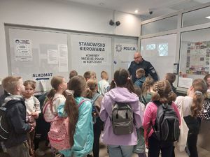 Na zdjęciu asp. sztab. Tomasz Surowiak funkcjonariusz rzeszowskiej komendy wraz z dziećmi przed dyżurką Komendy Miejskiej Policji w Rzeszowie.